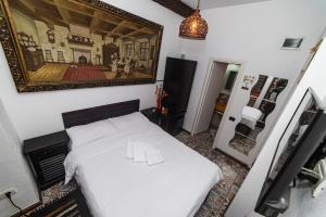 ein Schlafzimmer mit einem weißen Bett und einem Gemälde an der Wand in der Unterkunft Luky 12 in Braşov + 44 Fotos