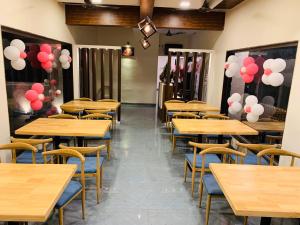 a row of tables in a restaurant with red and white balloons at Fortune Resort in Nagaon