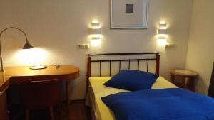 1 dormitorio con cama y escritorio con almohada azul en Hessisches Haus en Roßdorf