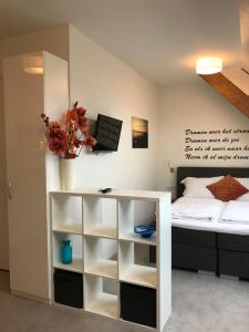 a bedroom with a bed and a white book shelf at Hendrikhof studio nr. 4 ‘het Spant’ in Westkapelle