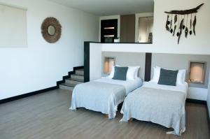 a bedroom with two beds and a mirror on the wall at Pura Lodge in Concepción