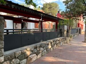 a stone retaining wall next to a sidewalk at ApartHosteriaPlaza in La Cumbre