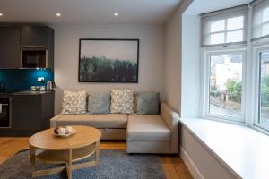 a living room with a couch and a table at Hampden Apartments - The Edward in Windsor