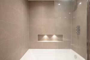 a bathroom with a shower with a glass door at Hampden Apartments - The Edward in Windsor