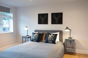 a bedroom with a bed with two lamps and a window at Hampden Apartments - The Edward in Windsor