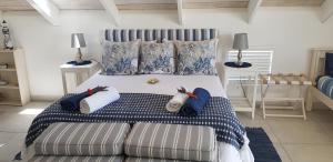 a bedroom with a bed and a couch with pillows at The Loft on Malmok in Paternoster