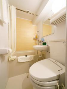 Baño blanco con aseo y lavamanos en Super Hotel Lohas Ikebukuro-Eki Kitaguchi, en Tokio