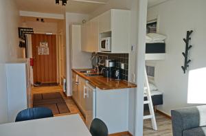 a small kitchen with a counter and a room with a bed at Arctic Lodge in Riksgränsen