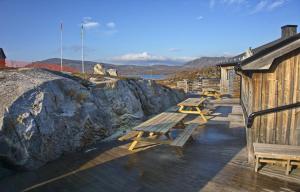 a row of picnic tables on a deck near a building at Arctic Lodge in Riksgränsen