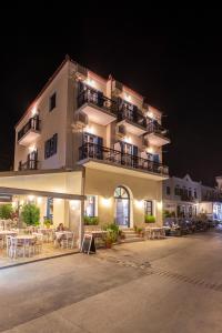 ein Gebäude mit Tischen und Stühlen in der Nacht davor in der Unterkunft Stelios Hotel in Spetses