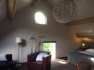 una camera con un letto e una sedia e una finestra di Vakantiehuis bij Bedaf a Uden