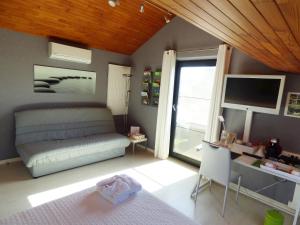 um quarto com uma cama, uma secretária e uma janela em B&B Le Jardin d'Epicure em Olne