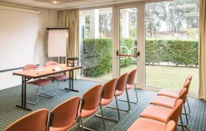 una sala riunioni con sedie, tavolo e lavagna bianca di Hotel ibis Porto Sul Europarque a Santa Maria Da Feira