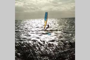 a person windsurfing in the ocean on the water at Vakantiehuisje Gaasterland Oudemirdum Friesland Nederland in Oudemirdum