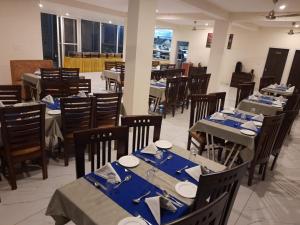 a dining room with tables and chairs with blue table settings at amravati resort in Solan