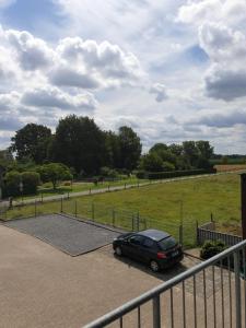 a car parked in a parking lot next to a field at Ferienwohnung Palmen in Gangelt