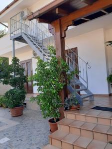 a house with a staircase and potted plants at LaRosa Maruggio in Maruggio