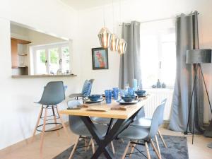 uma sala de jantar com uma mesa com cadeiras e uma sala de jantar em Villa Waulsort em Waulsort