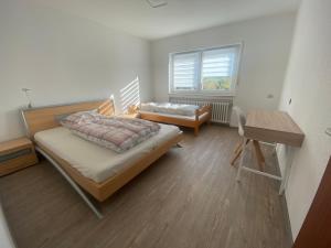 a bedroom with two beds and a table and a desk at Ferienwohnung Wasserturmblick in Bebra