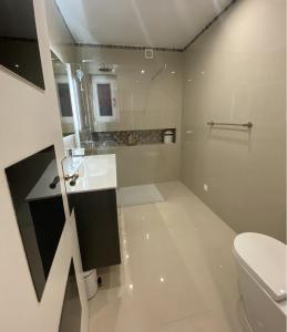 een witte badkamer met een toilet en een wastafel bij Villa CHELSEA in Vilamoura