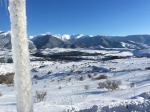 a snow covered field with mountains in the background at Appartements dans Chalet in Font-Romeu