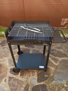 a grill with tongs on it sitting on a patio at Alojamiento rural LA JARA 2 in Robledillo de la Jara