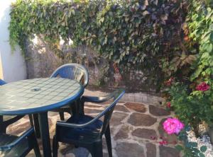 un patio con mesa, sillas y flores en Alojamiento rural LA JARA 2 en Robledillo de la Jara