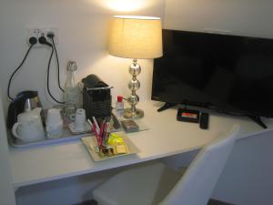 una scrivania con una televisione e una lampada di AGATHE chambres d'hôtes a Guérande