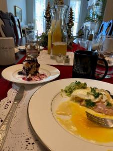 Belle Louise Historic Bed & Breakfast في بادوكا: طاولة مع طبقين من الطعام ومشروب