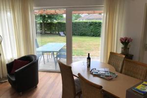 uma sala de jantar com uma mesa e uma garrafa de vinho em Rustig gelegen bungalow in mooi Havelte (Drenthe) em Havelte
