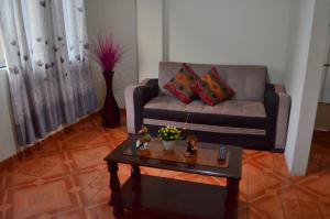 sala de estar con sofá y mesa de centro en Rosenverg House Lima Airport en Lima