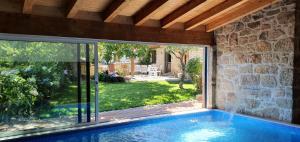 a swimming pool in a house with a large window at Casas de Campo da Barroca in Tabosa