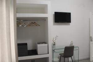 Habitación con escritorio y TV en la pared. en B&b Carpe Diem en Palermo