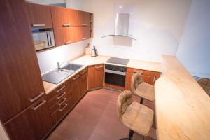 a kitchen with wooden cabinets and a counter top at Apartment Vodni with parking in Brno
