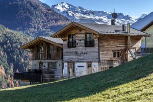 a house on a hill with mountains in the background at The Peak Sölden - Chalets mit Outdoor-Pool in Sölden