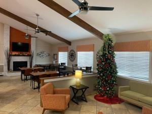 a living room with a christmas tree and a fireplace at Nichols Inn & Suites in Hastings