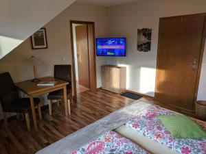 a bedroom with a bed and a table and a tv at Haus am Grasberg in Poppenhausen