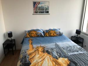 a bed with a painting of the statue of liberty at HYPER CENTRE - WIFI FIBRE GRATUIT - JERGWELOH - Le New Yorkais in Caen