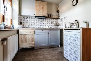 a kitchen with wooden cabinets and a tile wall at apartamenty bogówka 11 in Zakopane