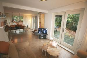 a living room with a couch and a tv in it at Fonteinbos in Oudemirdum