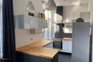 uma cozinha com armários brancos e um balcão de madeira em À deux PATENIER de Dinant em Dinant
