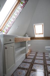 een badkamer met een wastafel en een toilet op een tegelvloer bij art-house 3 attic apartment with terrace in Děčín