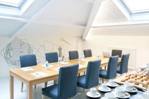 una sala de reuniones con mesa de madera y sillas azules en La Casa de Los Arquillos en Vitoria