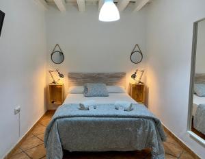 a bedroom with a bed with two towels on it at Pensi&oacute;n La Cantarera in C&aacute;diz
