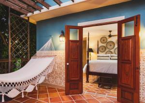 Un dormitorio con una cama y una hamaca. en Puertas, en Vieques