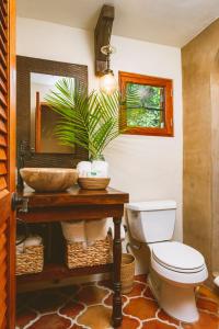 a bathroom with a toilet and a sink and a mirror at Puertas in Vieques