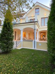 a large white house with a balcony and a yard at ApartamentS in Râşnov