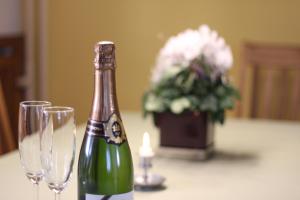a bottle of champagne and two glasses on a table at Landhaus Büttner Altenberg, zentral, familienfreundlich, Skihang & Erlebnisberg fußläufig in Kurort Altenberg