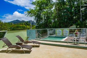 a patio with chairs and a swimming pool at Pousada do Tenório in Ubatuba