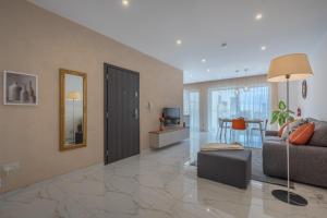 a living room with a couch and a television at White Sands in Mellieħa